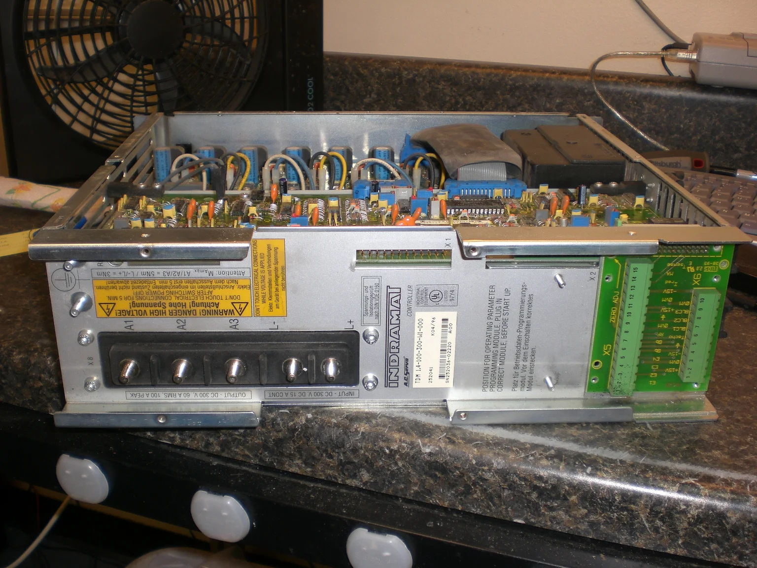 Litco TDM1.4-100-300-W1-000 controller on the repair bench with its top cover removed and tag visible